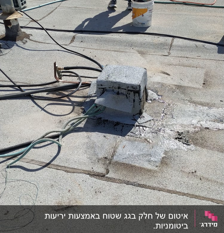 אדם עומד ליד דלי על גג עם חוטים ואיטום